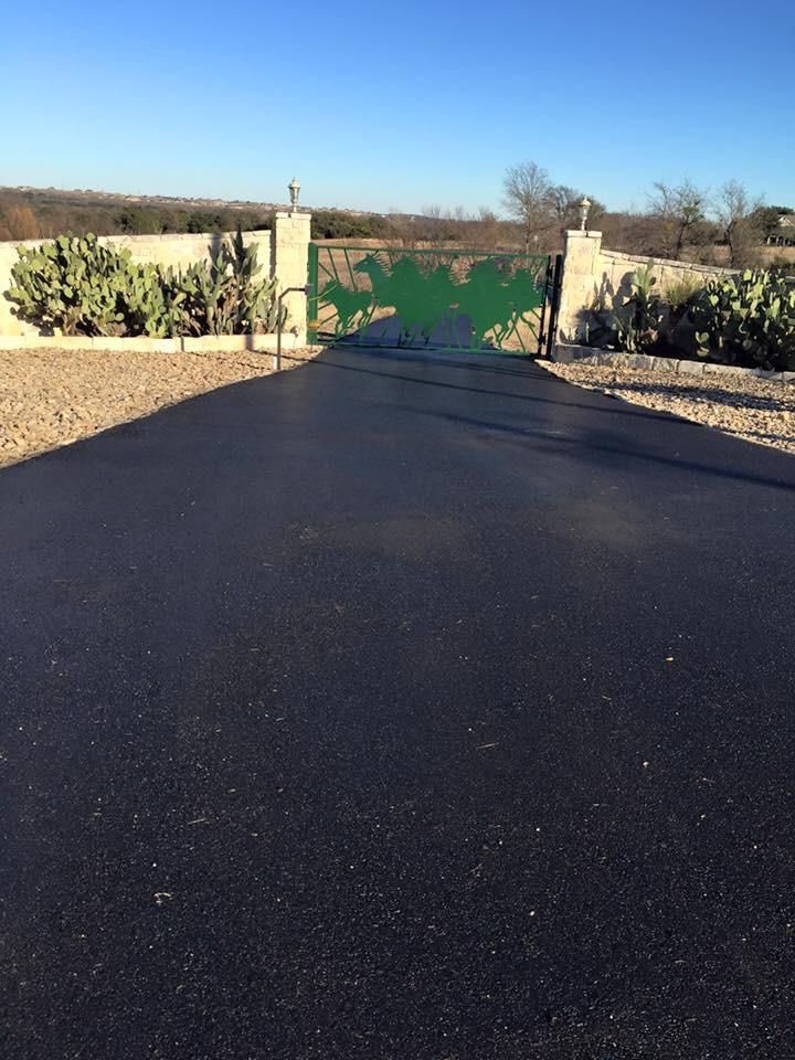 Paved driveway through cactus-lined gate