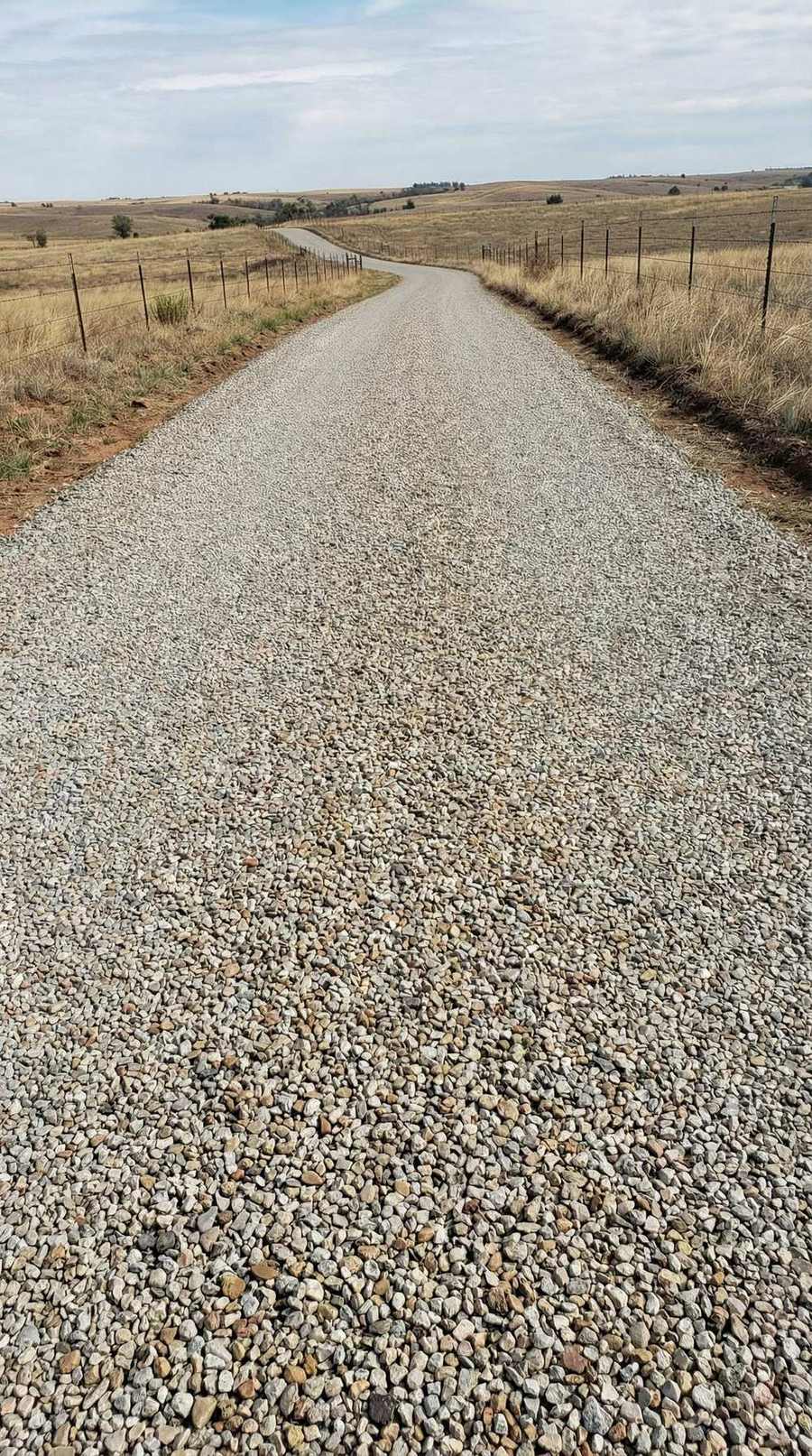 Paved road through brown grassland hills
